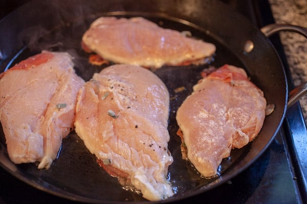 Cooking the chicken saltimbocca in a skillet.