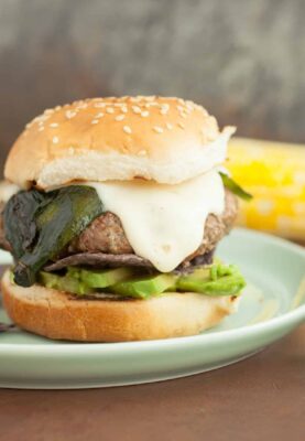 Santa Fe Burgers: One of my favorite burgers to toss on the grill in the summer. Topped with a spicy cheese sauce, roasted poblano peppers, and crispy blue corn chips! | macheesmo.com