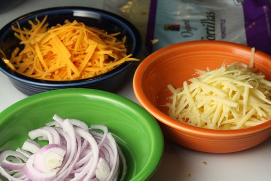 Cheese and toppings prepped in bowls.