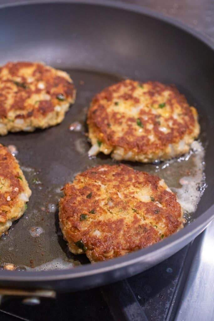 Frying the chickpea patties in a skillet.