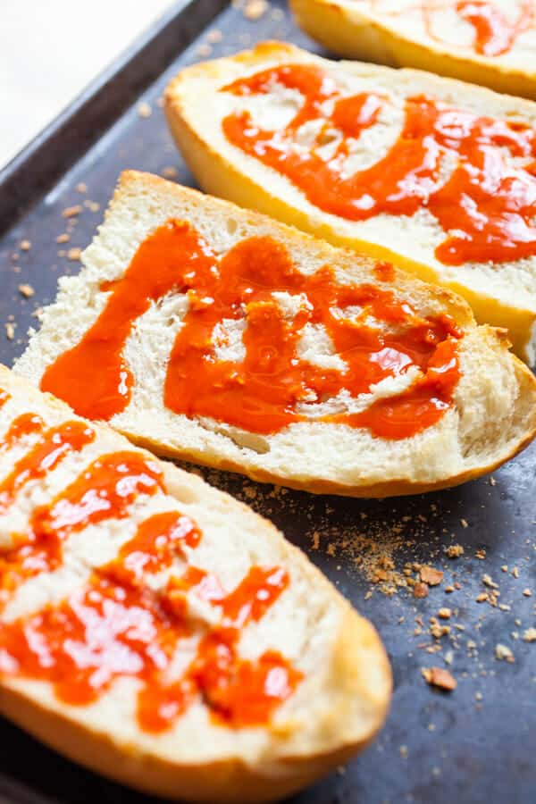 Adding hot sauce to toasted bread.