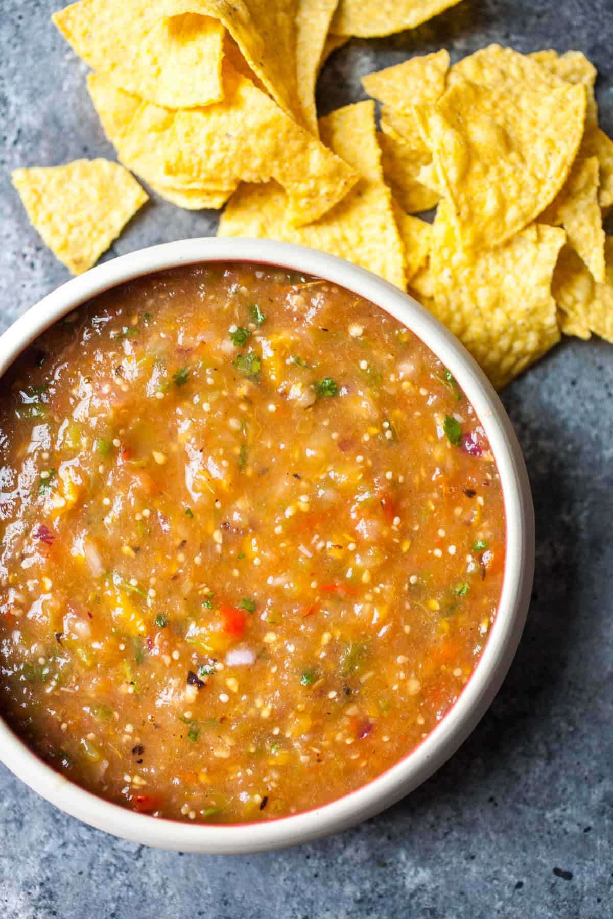 Easy grilled salsa with fresh tomatoes, tomatillos, onions, and sweet peppers. All charred on a grill and blended together. The best salsa you'll have this summer and easy to make!