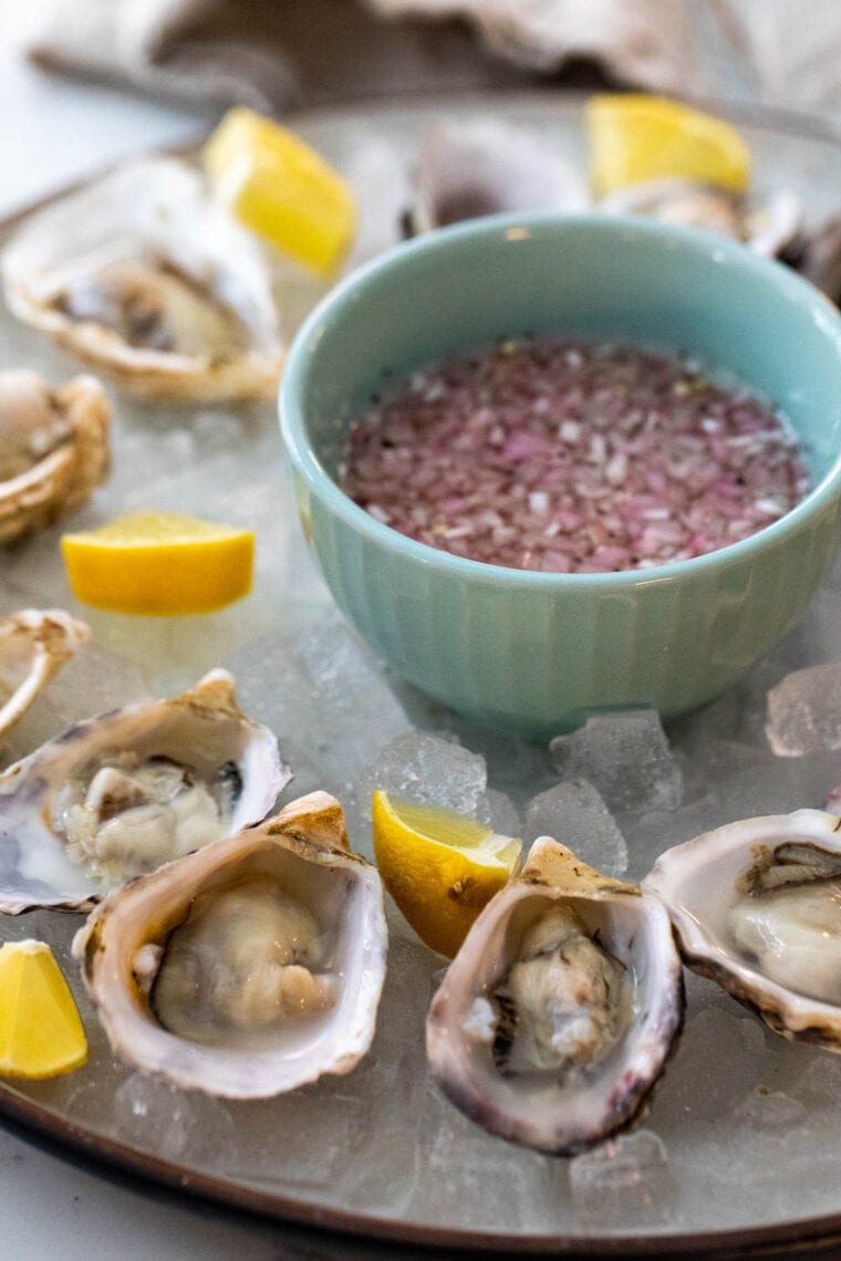 A plate of oysters with mignonette sauce.