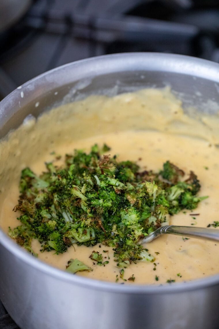 Adding broccoli to the queso.
