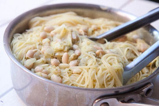 Tossing the pasta with the artichoke sauce.