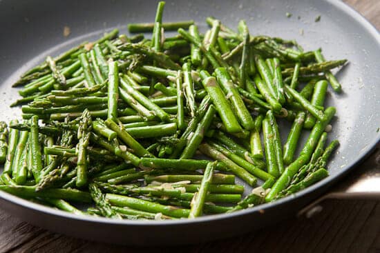 Sautéing asparagus in a skillet. 