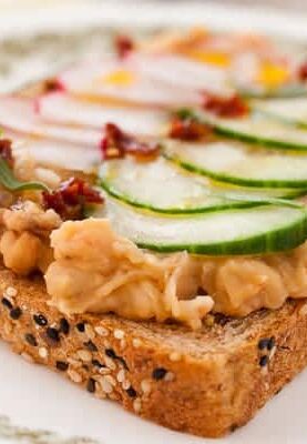 Breakfast White Bean Toasts: Creamy and savory white beans mashed together with sun-dried tomatoes and shallots and served on toast with a crispy fried egg and thin, crunchy veggies. A great hearty breakfast and it's a quick 15 minute prep!