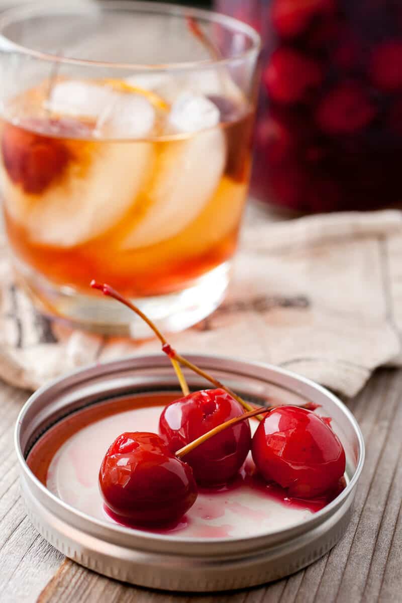 Homemade Cocktail Cherries: These ripe, fresh cherries are jarred in a spiced brandy mixture for a few weeks and perfect in any dark cocktail. So much better than the store-bought bright red version! | macheesmo.com