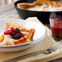Fresh Peach Dutch Baby: In-season, perfect peaches cooked with a fluffy pancake in a cast iron skillet and served with a quick berry syrup. A perfect late summer breakfast! | macheesmo.com