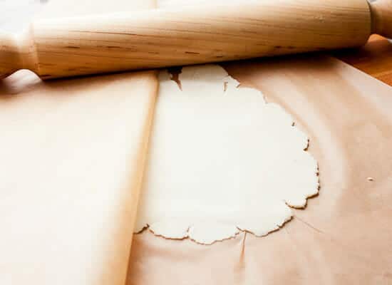 Rolling masa between parchment paper.