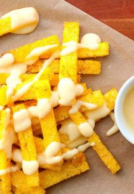 Baked Polenta Fries with Queso! Crispy (and super-easy) baked polenta fries dipped or drizzled with a quick homemade queso sauce. You're gonna wanna make this ASAP.