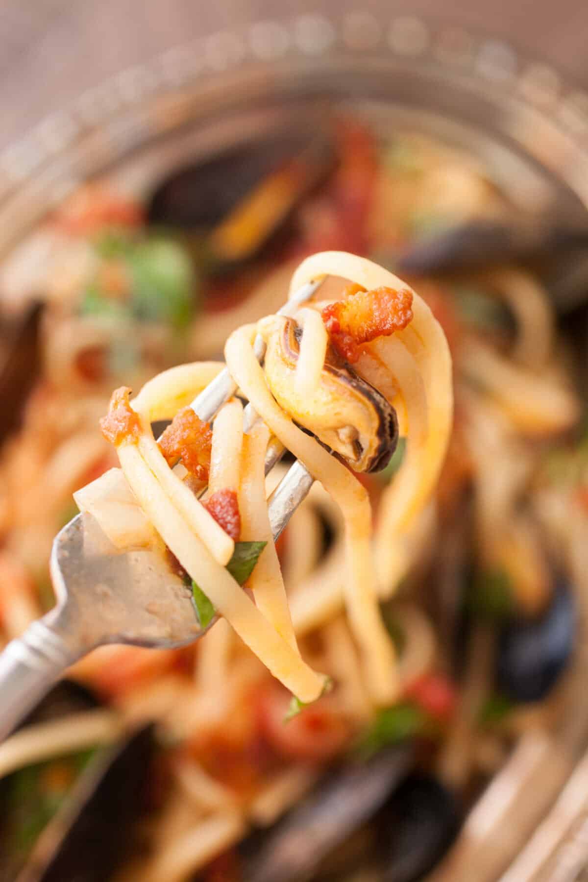 Spicy Mussel Linguine: This is a classic Italian dish packed with fresh mussels plus a light tomato sauce and crispy bacon. Surprisingly easy to make and so delicious. Don't forget the bread! | macheesmo.com