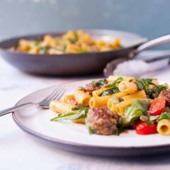 Easy Pesto Pasta with Sausage: This pasta dish is perfect comfort food. Simple flavors with sweet Italian sausage, arugula, and grape tomatoes, tossed with pasta and pesto. One of my new favorites! | macheesmo.com