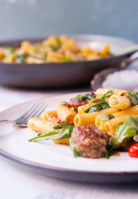 Easy Pesto Pasta with Sausage: This pasta dish is perfect comfort food. Simple flavors with sweet Italian sausage, arugula, and grape tomatoes, tossed with pasta and pesto. One of my new favorites! | macheesmo.com