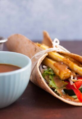 Crispy Tofu Wraps with Spicy Peanut Sauce: These are one of my favorite healthy vegetarian meals. Crispy tofu that's caramelized with a little maple syrup and loaded up with crunchy veggies and an easy spicy peanut sauce! YUM! | macheesmo.com