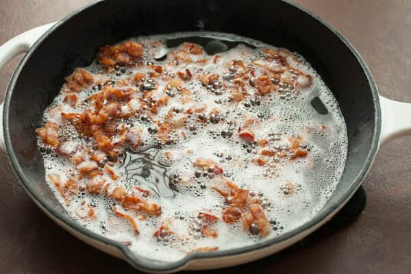 Crisping up bacon in a skillet.