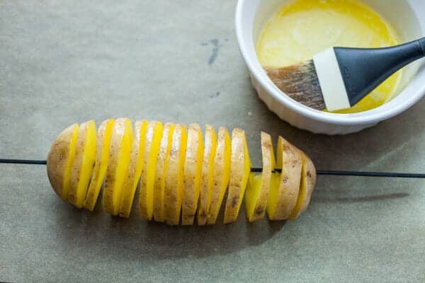 Brushing butter on the tornado potatoes.