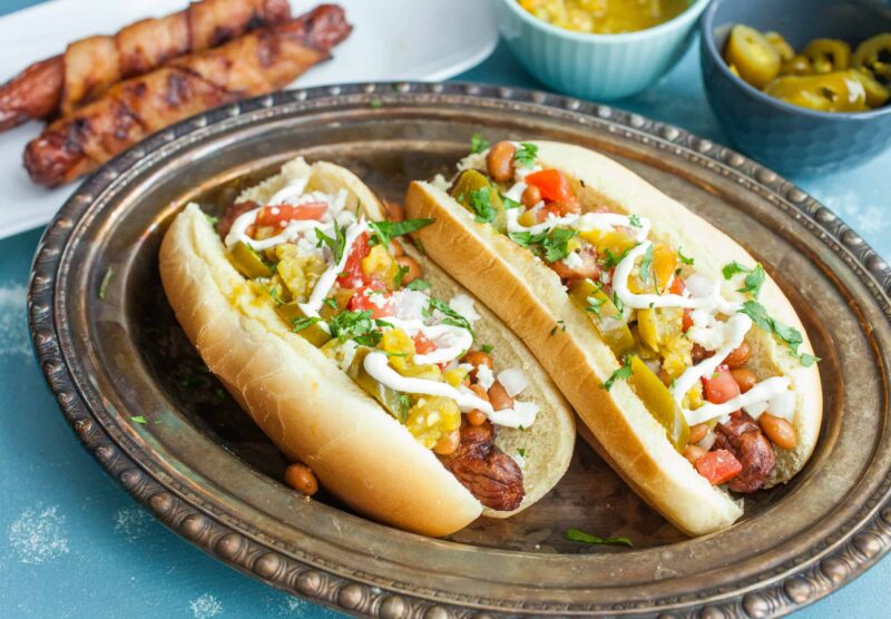 Sonoran Hot Dogs: Bacon wrapped grilled hot dogs topped with ALL the toppings you could ever want. These are the perfect jazzed-up hot dog for a backyard party! Inspired by the popular Tucson version. | macheesmo.com