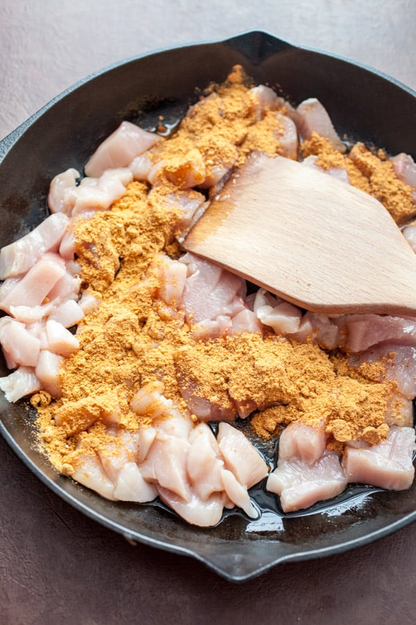 Cooking chicken and spices in the skillet for taco skillet.