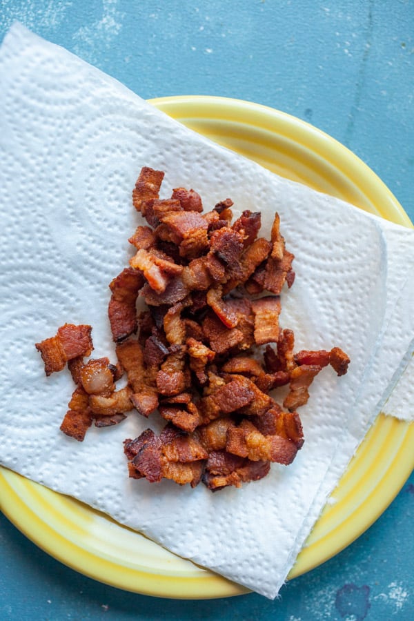 Crispy bacon draining on a plate.