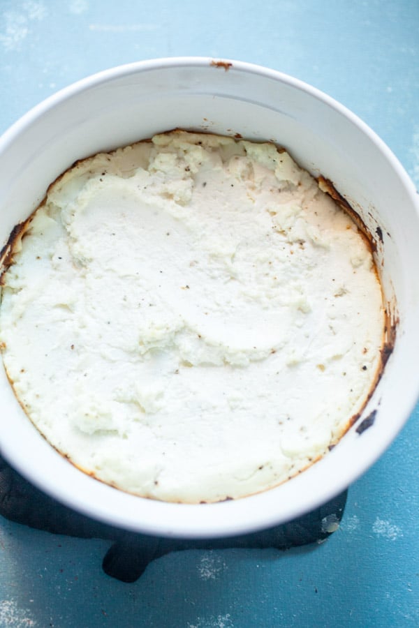Baked Goat Cheese in a white dish.