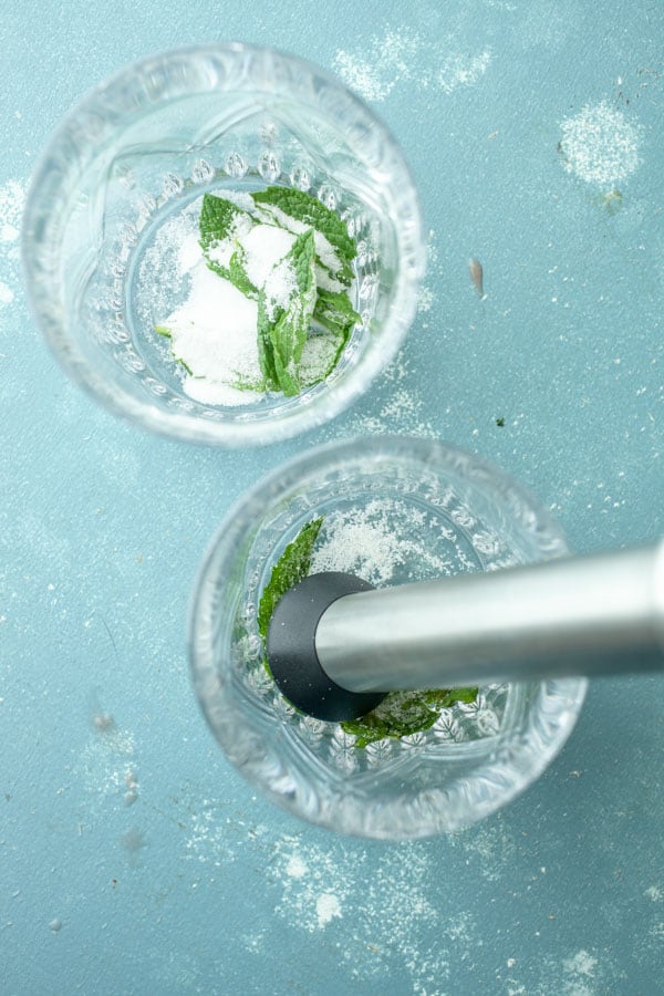 Muddled Mint and sugar for watermelon bourbon cocktails.