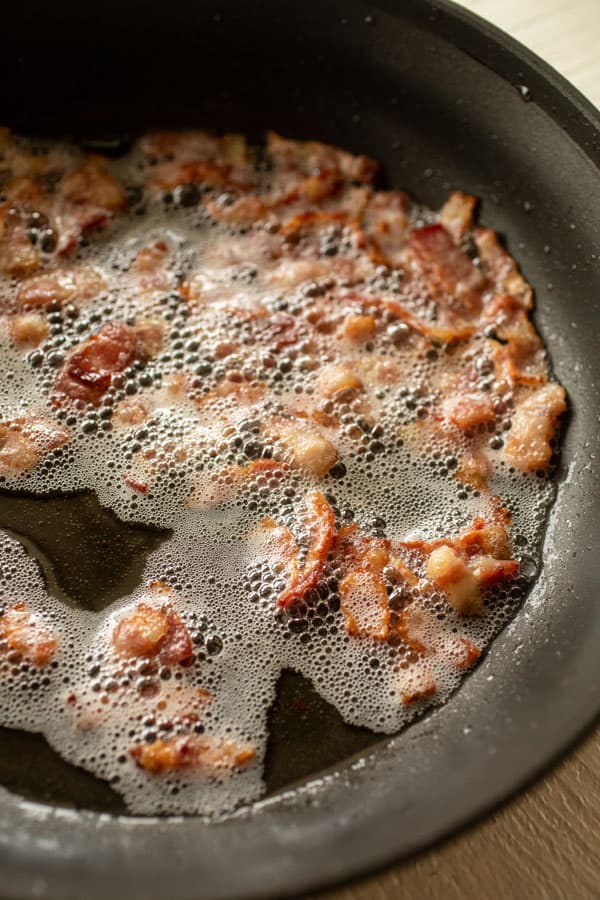 Bacon cooking in a skillet for breakfast casserole.