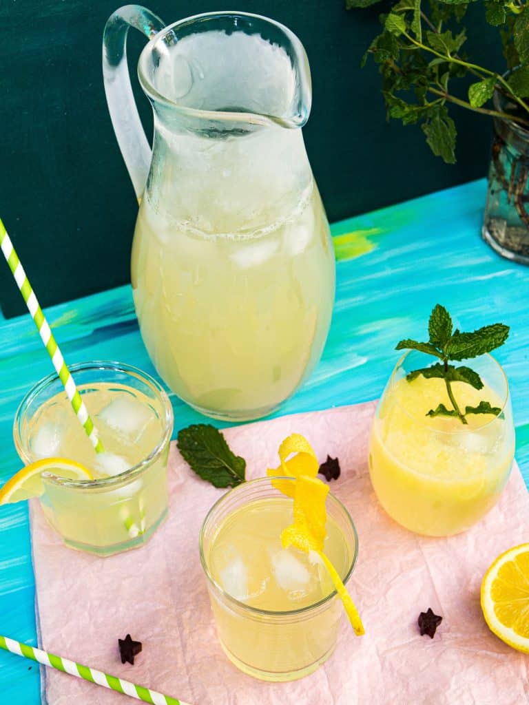 3 glasses and a pitcher of lemonade with mint garnish 