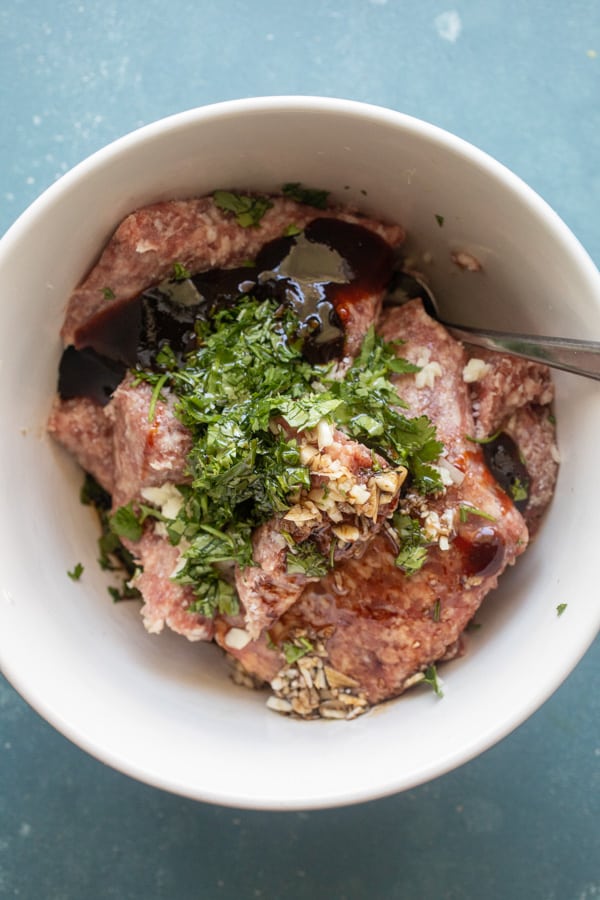 Meatball mixture in a bowl for spicy pork meatballs.