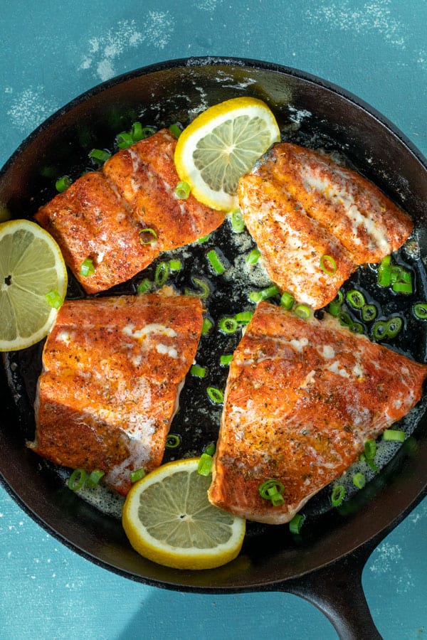 Garnished blackened salmon in cast iron skillet.