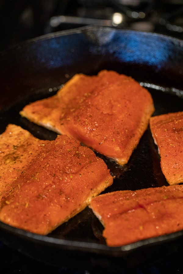 Starting to sear the salmon with blackening seasoning in cast iron.