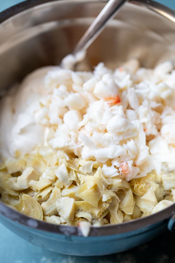 Adding artichoke and crab to the dip.