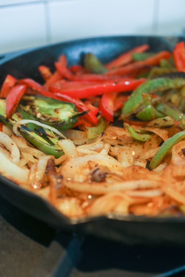 Cooking fajita veggies in a skillet.