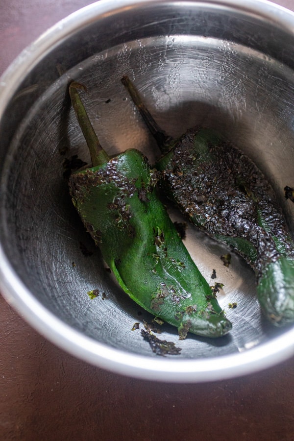 Steaming the peppers and peeling them.