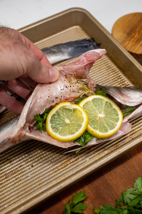 Stuffing fish with lemon and parsley.