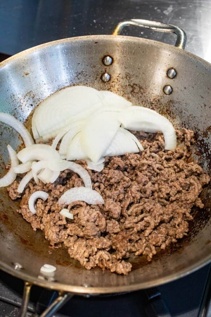 Beef and onions cooking in wok.