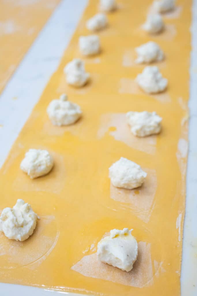 Adding filling to pasta dough.