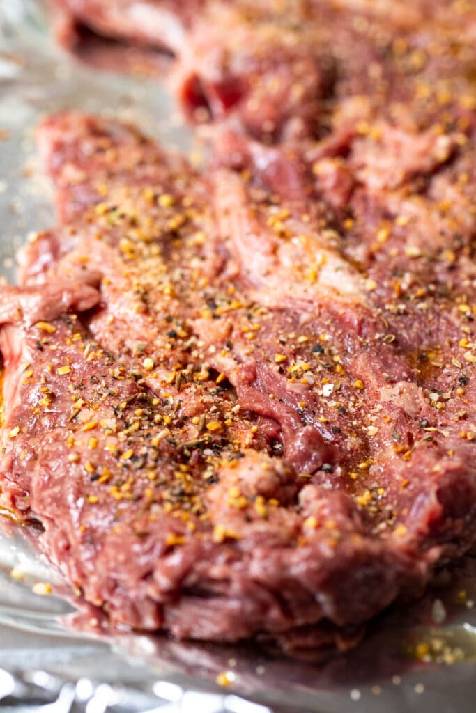 Raw cut of skirt steak seasoned with blend.