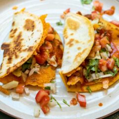 Smashed tacos with cheese and refried beans.