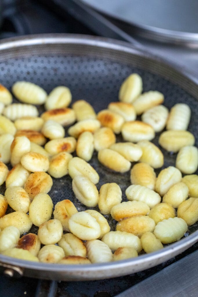 Gnocchi cooked in butter in a skillet.