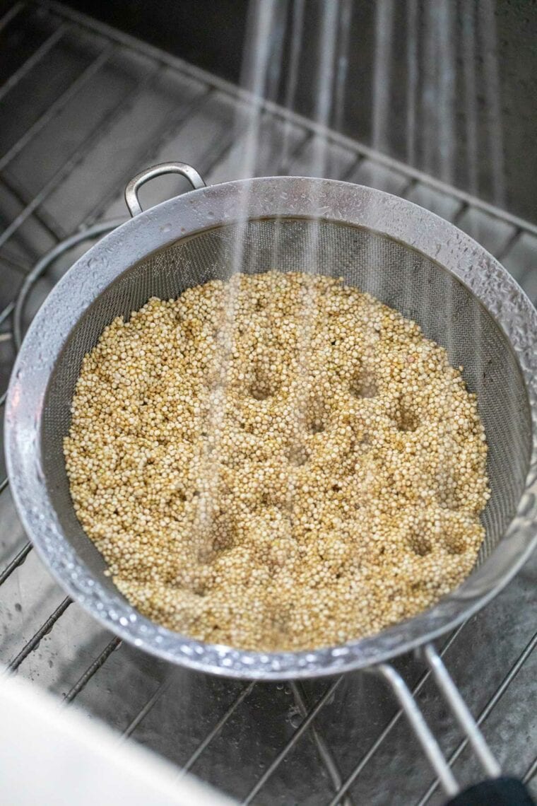 Rinsed quinoa in metal strainer.