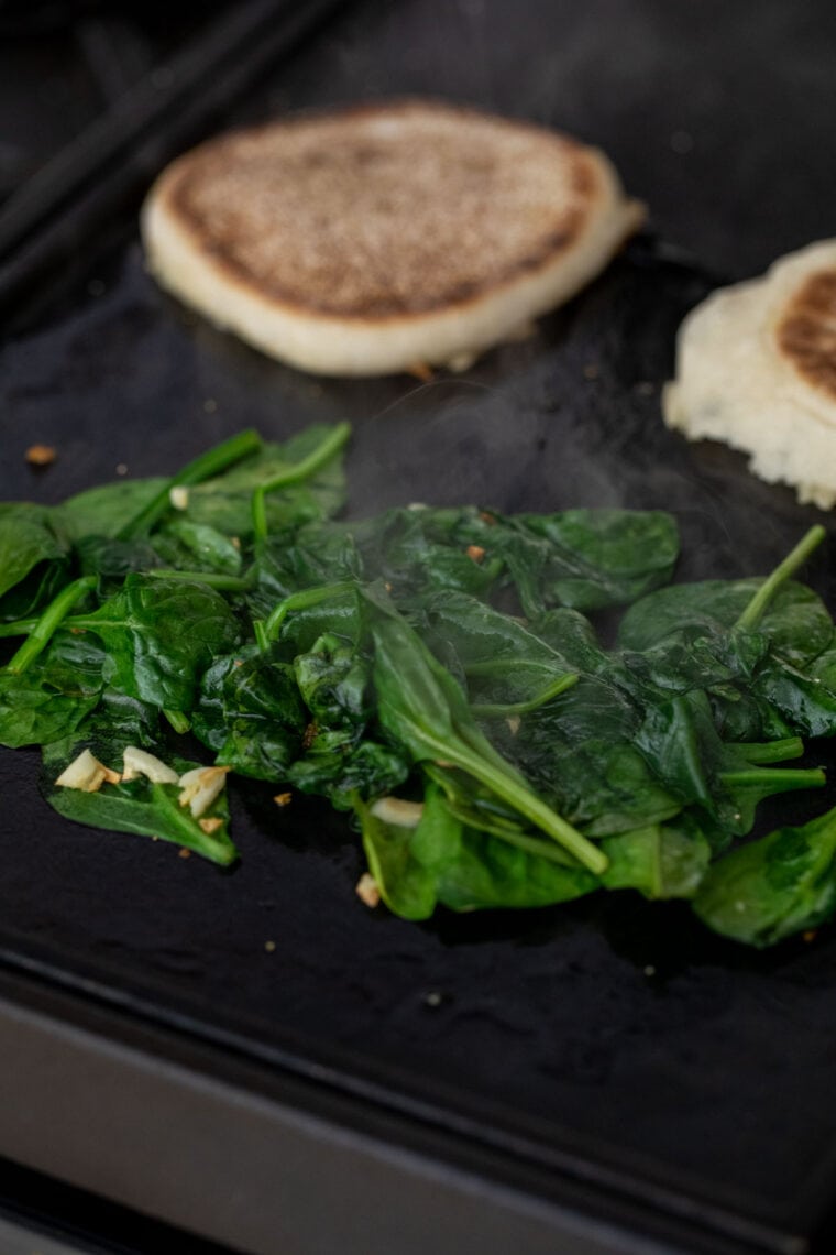 Cooking spinach for sandwich.