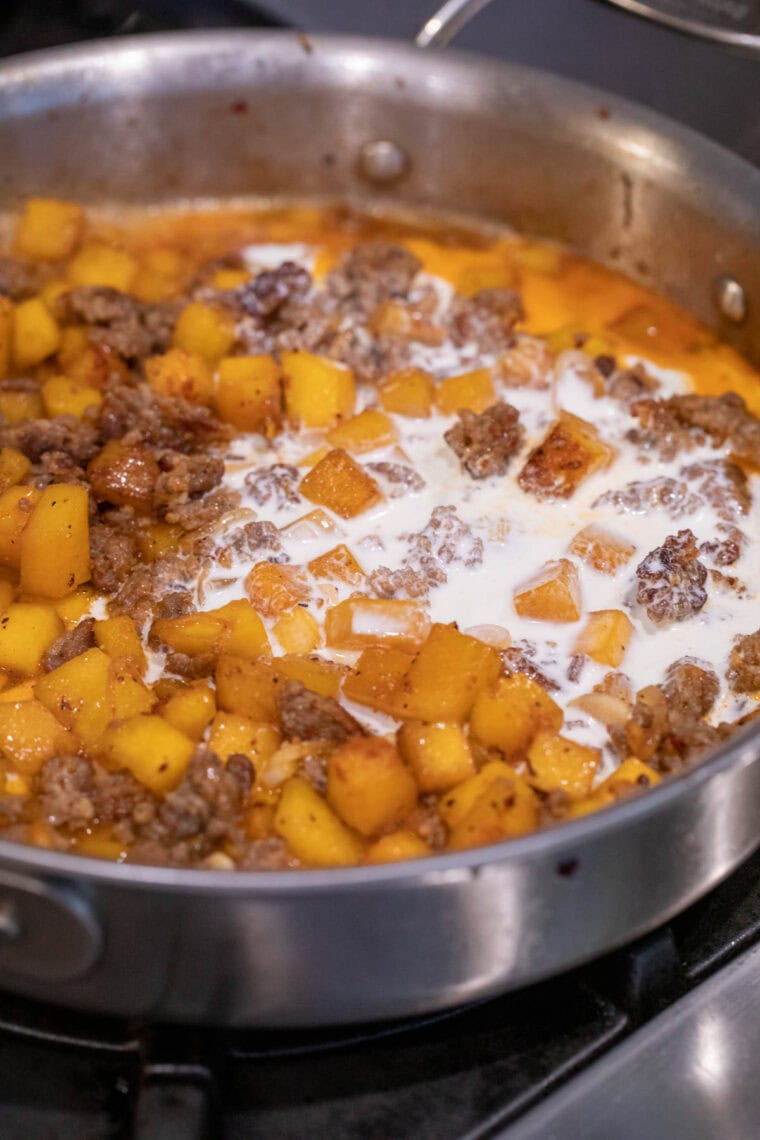 Adding cream to the skillet.