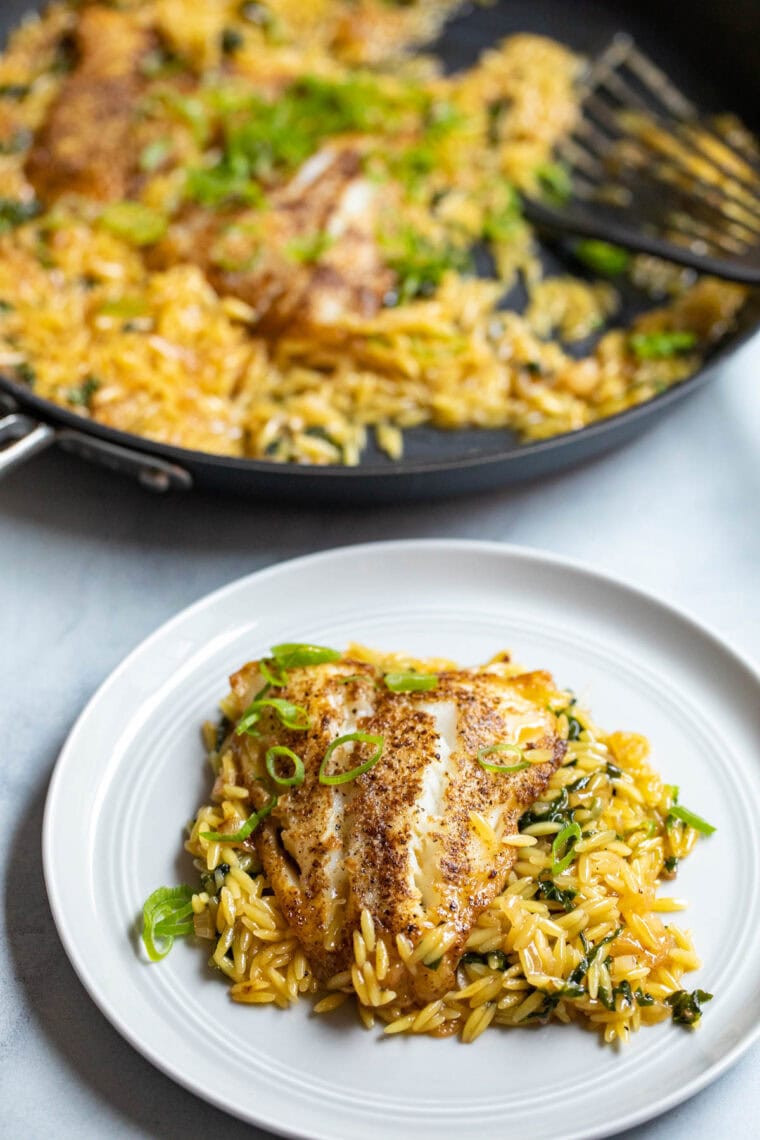 Seared cod with coconut orzo on a plate.