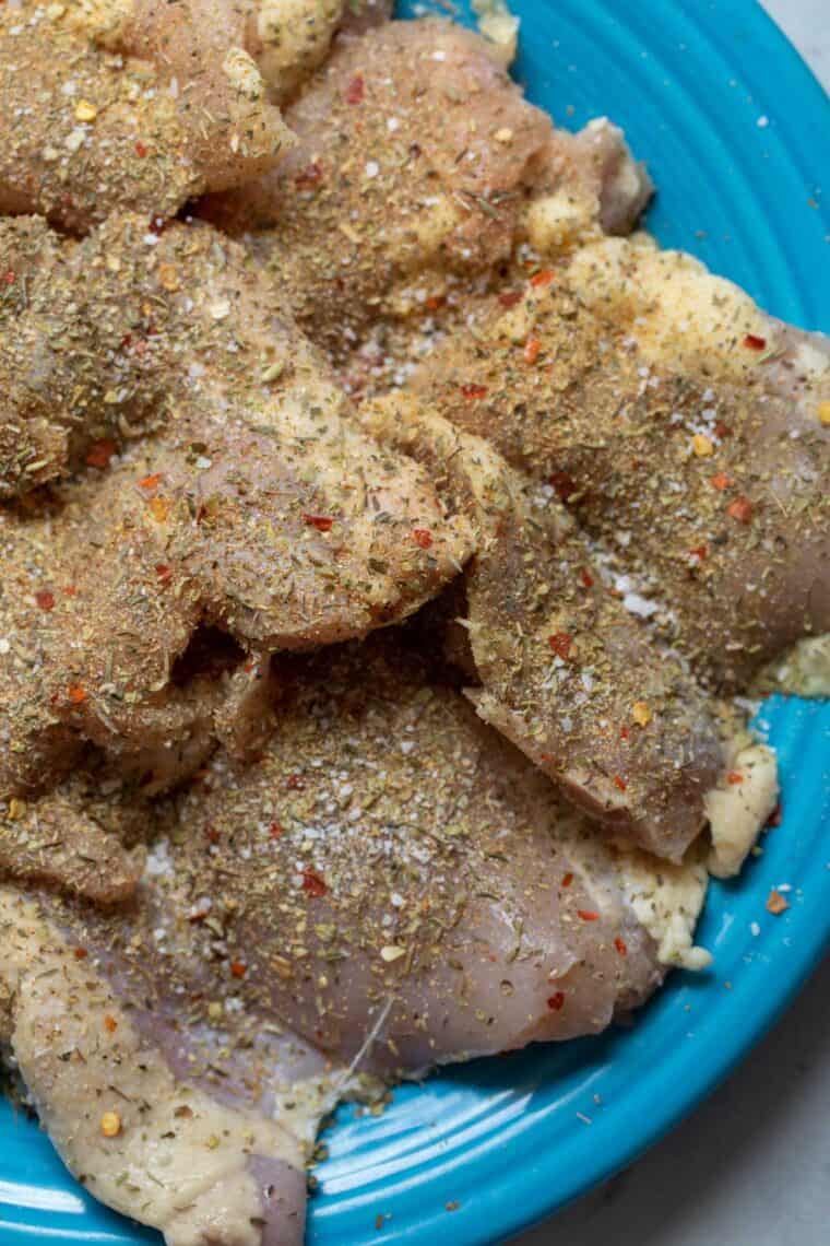 Chicken thighs seasoned for orzo bake.